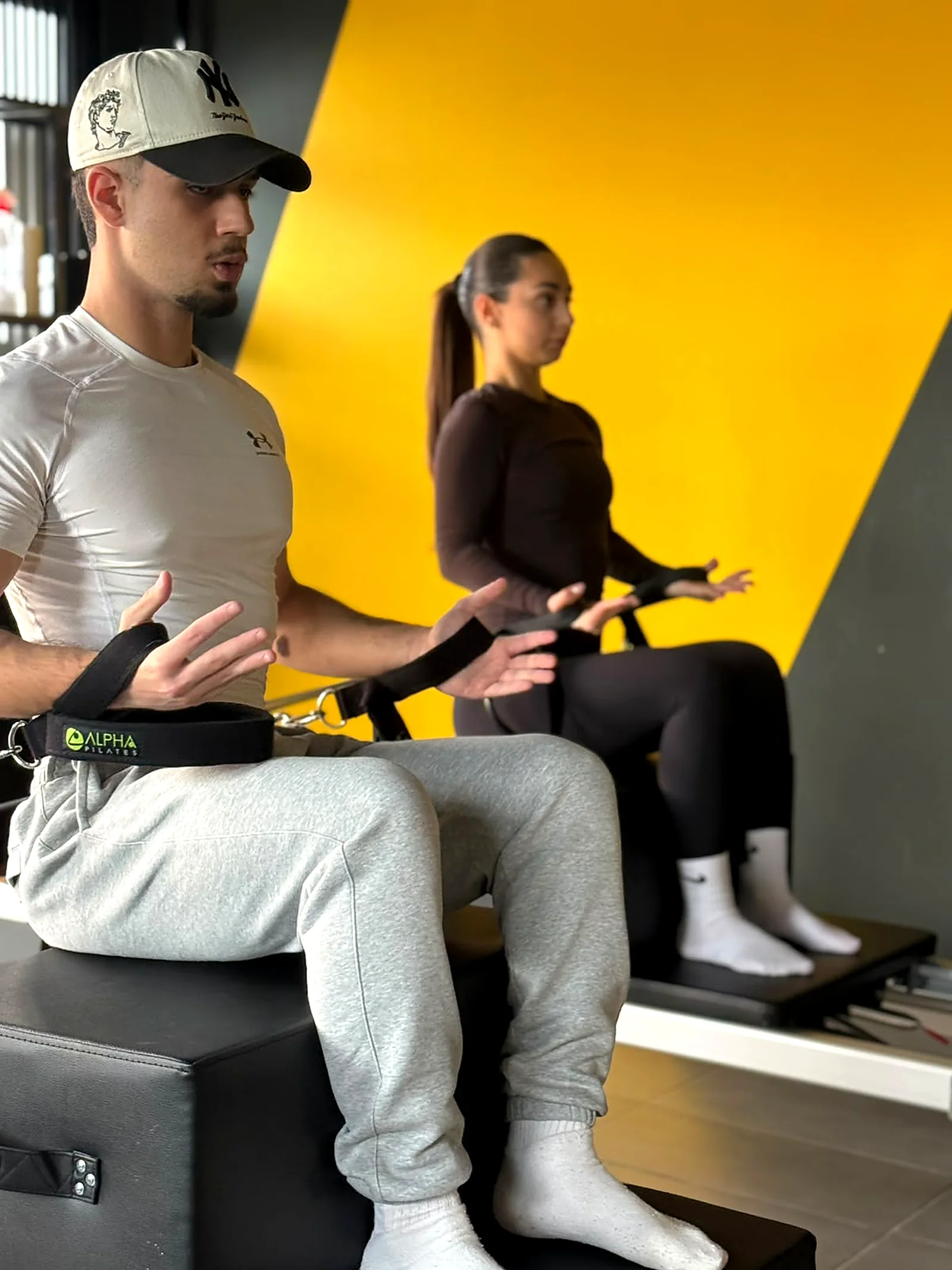 Pilates Reformer instructor coaching a client on the reformer box in Peyia