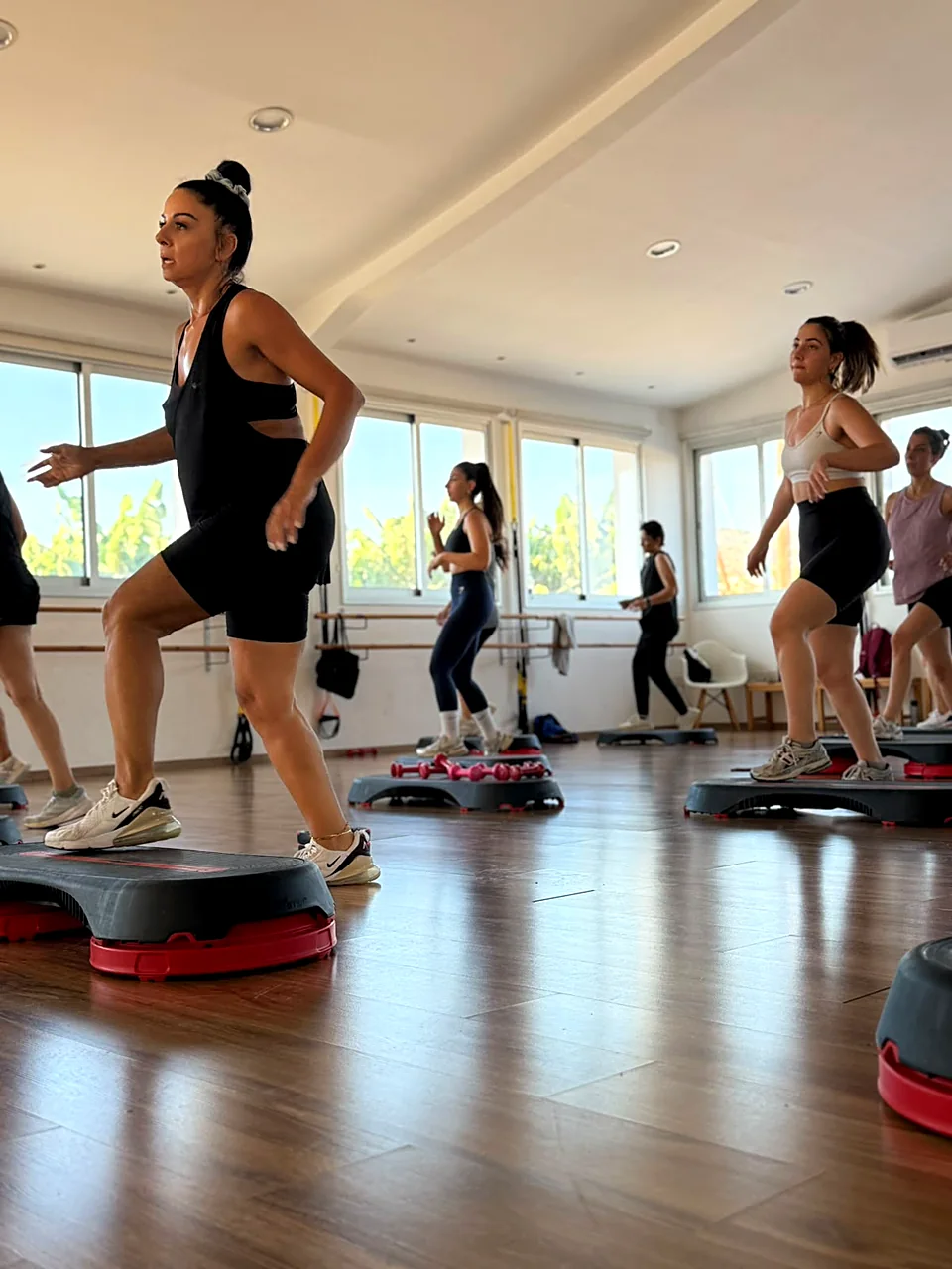 Step aerobics class with instructor in a bright studio in Peyia, Paphos