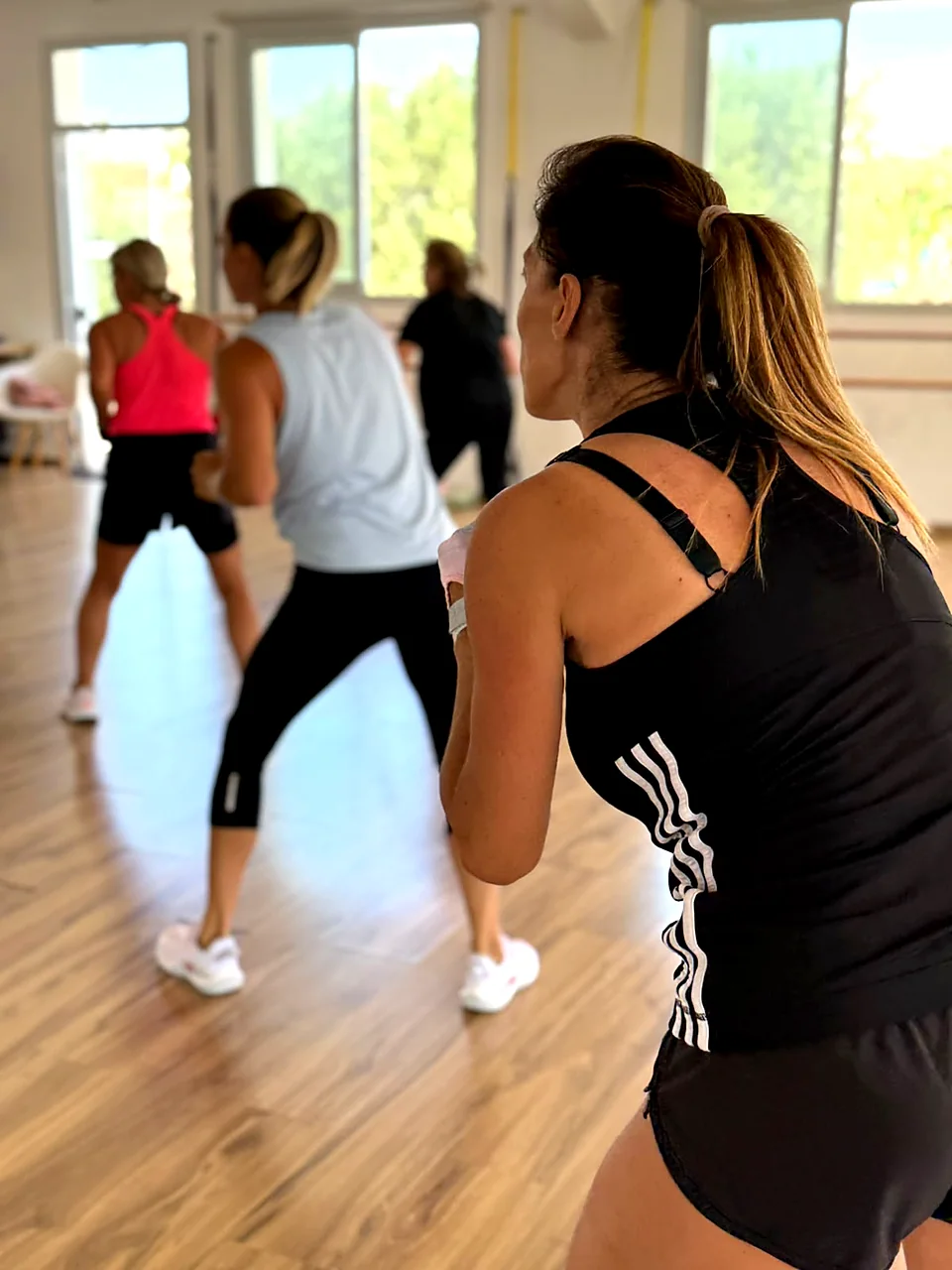 Women dancing in a Zumba group fitness class in a bright studio in Peyia, Paphos