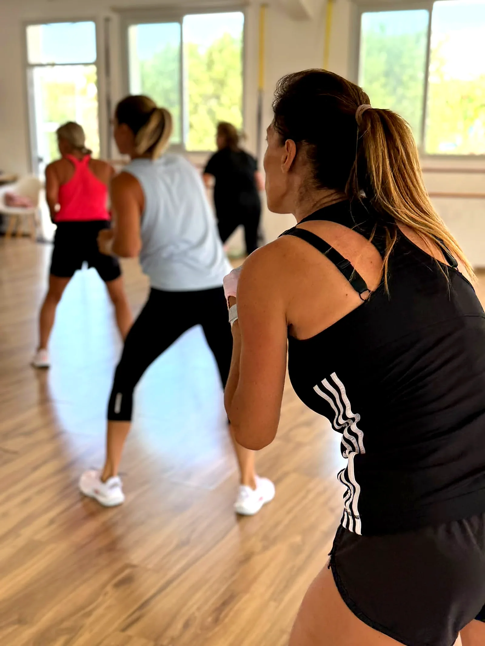 Women dancing in a Zumba group fitness class in a bright studio in Peyia, Paphos